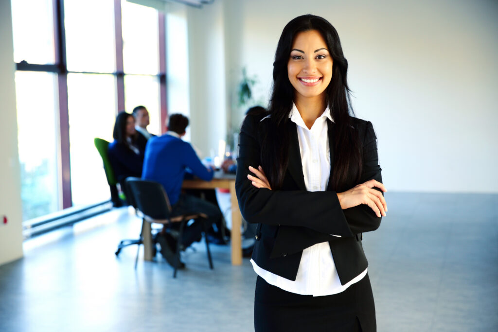 happy businesswoman standing in front of a business meeting